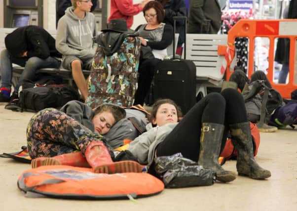 Leeds Station is transformed into a temporary campsite as muddy Leeds Festivalgoers sit around waiting for trains after the three day event at Bramham Park. Picture: Ross Parry Agency