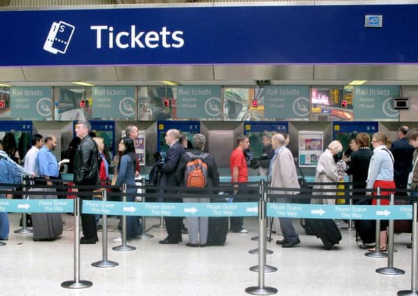 People queuing for train tickets at Victoria station, London.