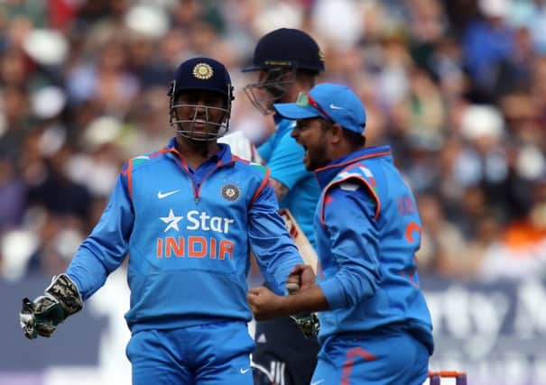 India's Suresh Raina (right) celebrates catching out England's Ben Stokes with captain MS Dhoni.