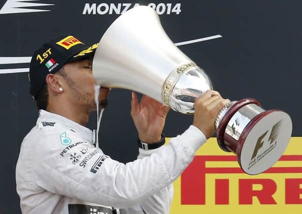 Lewis Hamilton sups champagne from the trophy after his victory yesterday in the Italian Formula 1 Grand Prix at Monza (Picture: Antonio Calanni/AP).