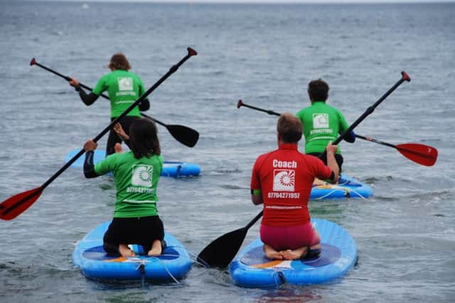 Luke Hutchinson, left, an associate of Whitby Surf School and its head Sam Pepler lead the paddleboarders to dry land.