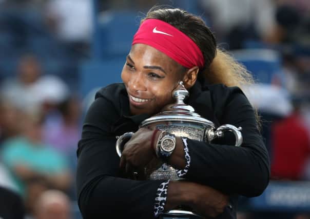 Serena Williams, of the United States, hugs the championship trophy after defeating Caroline Wozniacki, of Denmark in New York. (AP Photo/Mike Groll)