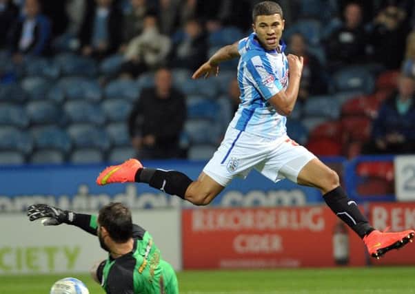 Nahki Wells of Huddersfield Town is denied by Scott Carson of Wigan Athletic