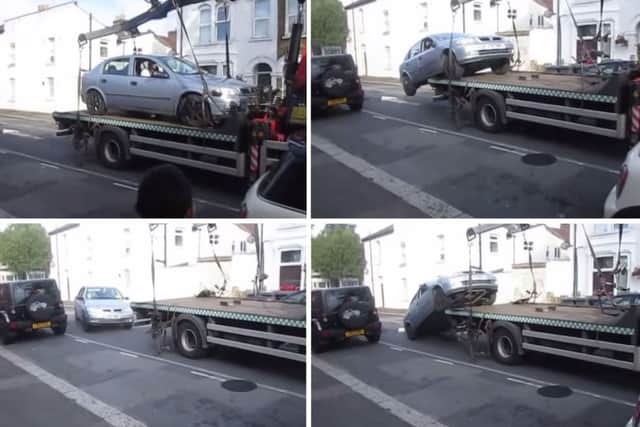 A driver taking his car off a lorry before it was taken away by council parking contractors