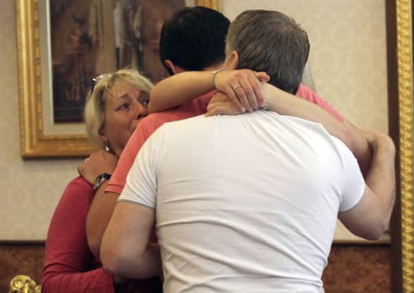 Family members of Hannah Witheridge hug each other at the Royal Thai Police headquarters in Bangkok