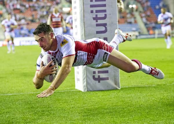 Wigan's Matty Smith goes over for their second try of the first half against  Huddersfield Giants.