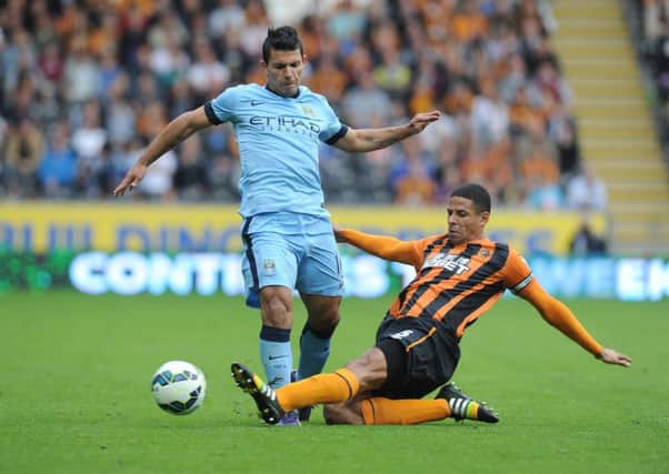 Manchester City's Sergio Aguero is tackled by Hull City's Curtis Davies.