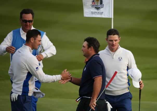 Europe's Martin Kaymer left shakes hands with USA's Patrick Reed after the foursomes matches.