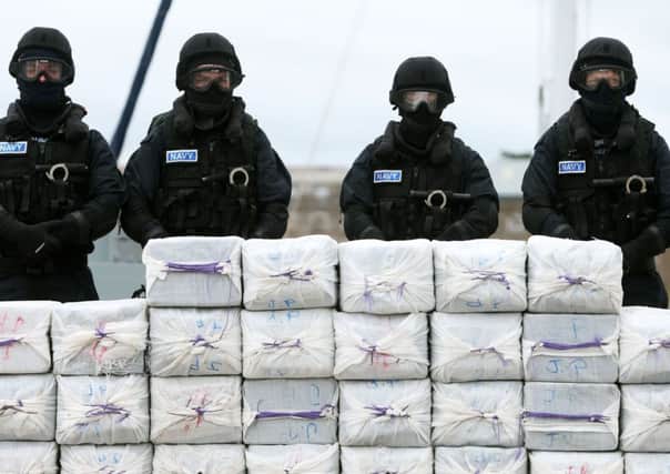 Members of the navy stand behind cocaine taken from onboard the yacht Makayabella in Haulbowline naval base, Cobh, Co Cork