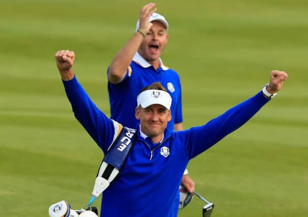 Europe's Ian Poulter, front, celebrates with Lee Westwood's caddy Billy Foster.