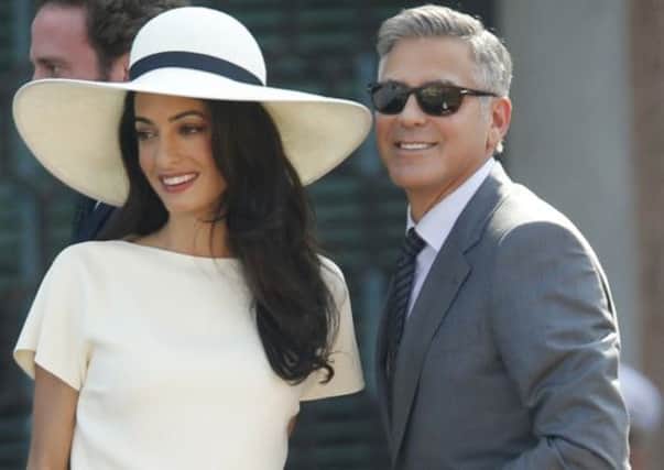 George Clooney, flanked by his wife Amal Alamuddin, arrives at the city hall for their civil marriage ceremony in Venice