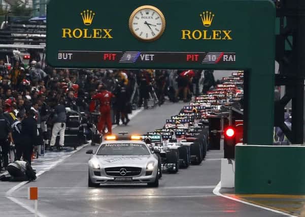 A safety car and F1 cars wait for the resumption of the Japanese Formula One Grand Prix.
