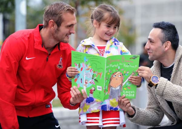 Bradford City striker James Hanson and boxer Tasif Khan, joined six-year-old Molly Thornton at the Bradford Literacy Campaign book giveaway launch.