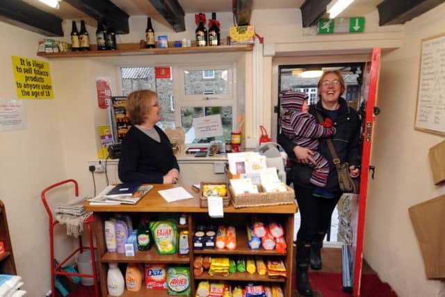 Lorna Chapman, a volunteer helper, greets a customer on entering the Little Shop.