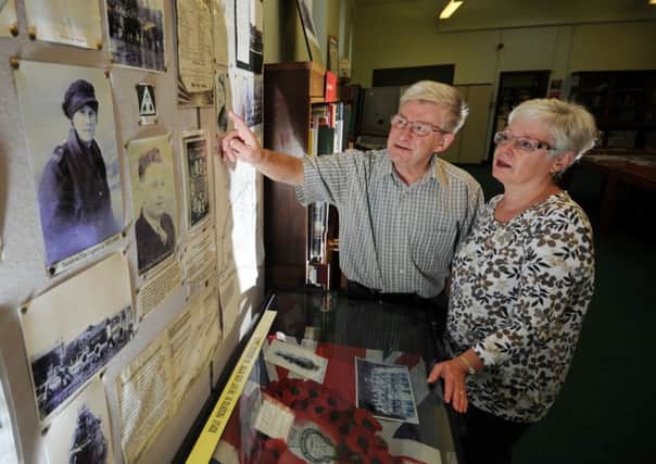 Bob Lawrence and his wife Jacki looking at photos of the 'Barnbow lasses'