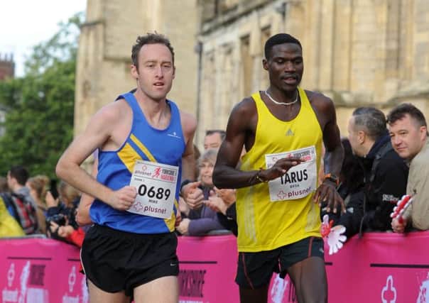 Competitors Mike Burrett (City of Leeds) and Elly Tarus in the plusnet Yorkshire Marathon pass York Minster in the 2013 race.