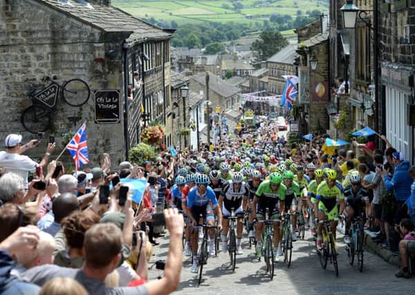 The peloton rides up Main Street as stage two of the Tour de France passes through Haworth.