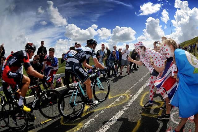 Fans cheer on cyclists as they tackle the Holme Moss climb on the Tour de France . Picture by Simon Hulme