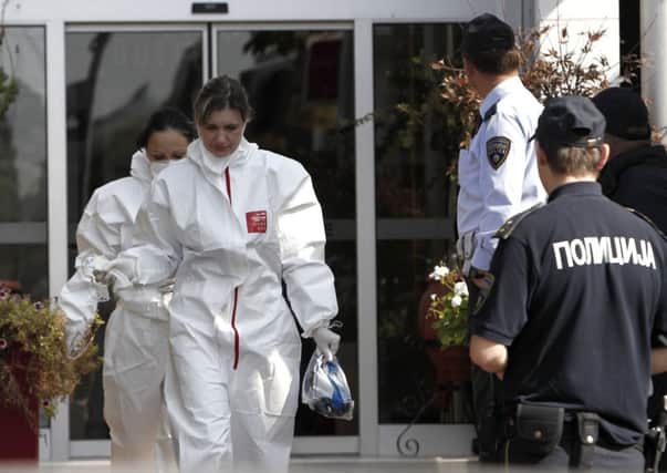 Health workers wearing protective clothing come out from the hotel from where a 58-year-old Briton was taken Thursday to hospital and died shortly of severe internal bleeding, in Skopje, Macedonia