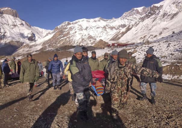 Soldiers carry avalanche victimsin Thorong La pass area, Nepal