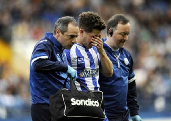 BAD DAY: Owls midfielder Sam Hutchinson leaves the field injured. Picture: Steve Ellis.