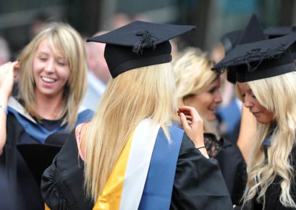 Students celebrate graduation. Report warns graduates now face record levels of debt.