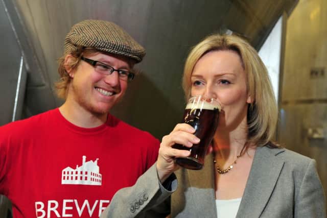 Ilkley Brewery's Luke Rowen offers Enviroment Secretary Liz Truss a pint during her visit today