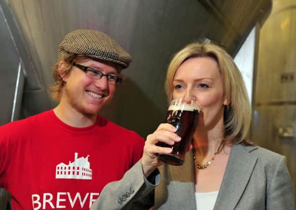 Ilkley Brewery's Luke Rowen offers Enviroment Secretary Liz Truss a pint during her visit today
