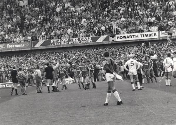 Players make their way back to the dressing rooms as fans try to escape at Hillsborough in 1989