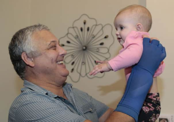 Hand transplant patient Mark Cahill with granddaughter, Dakota, two years after his operation.