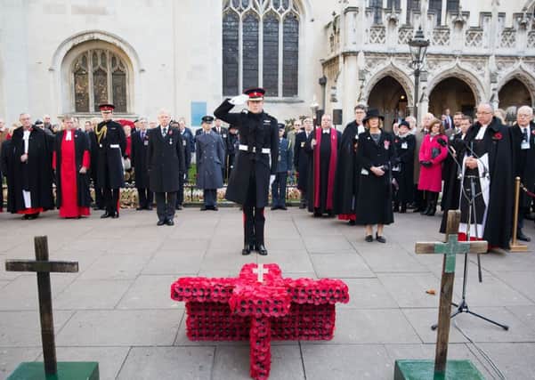 Prince Harry salutes in front of a Cross of Remembrance when he opened the 86th Field of Remembrance at Westminster Abbey