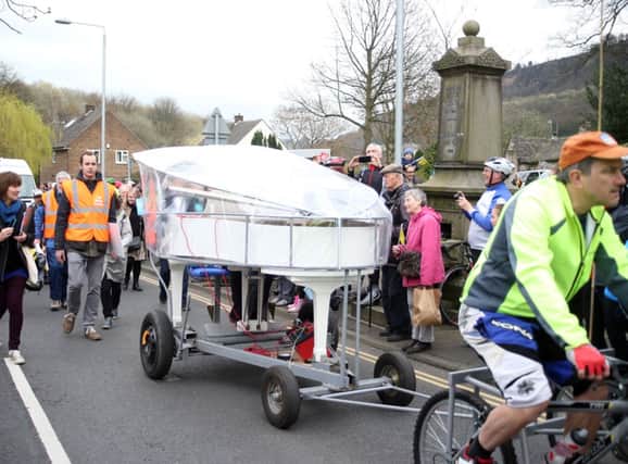 Cyclists pulling a mini-grand piano from Mytholmroyd up Cragg Vale.
