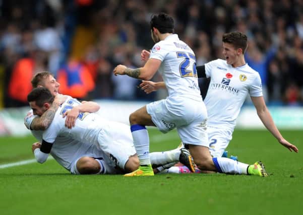 Leeds United's Liam Cooper is mobbed as he celebrates his goal.