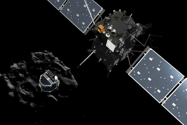 An artist rendering by the ATG medialab of lander Philae separating from Rosetta mother spaceship and descending to the surface of comet 67P