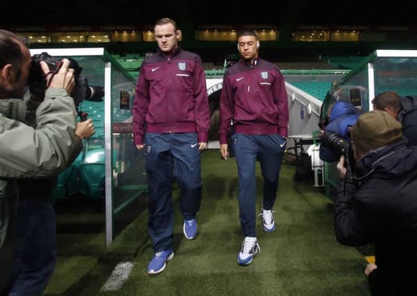 INTO BATTLE: Wayne Rooney, left, and Alex Oxlade-Chamberlain step out on to the pitch at Celtic Park ahead of tonights eagerly-awaited encounter with Scotland.