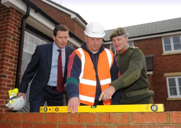 Jeff Fairburn, CEO at Persimmon plc with ex-forces serviceman Ross Wilson who is training to be a bricklayer with Brigadier Greville Bibby looking on.