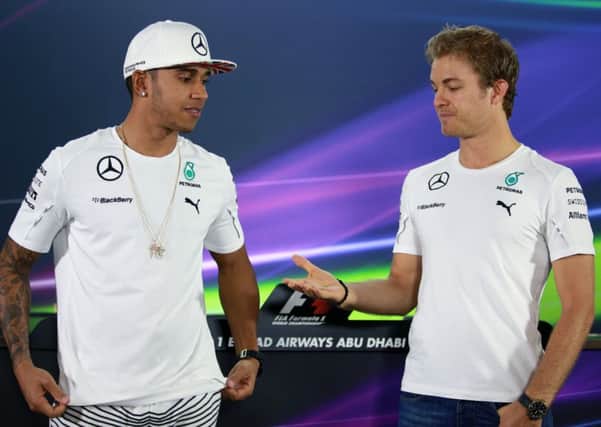 SHAKE ON IT: Fierce rivals and team-mates Lewis Hamilton, left, and Nico Rosberg show some discomfort before shaking hands ahead of Thursday's press conference.