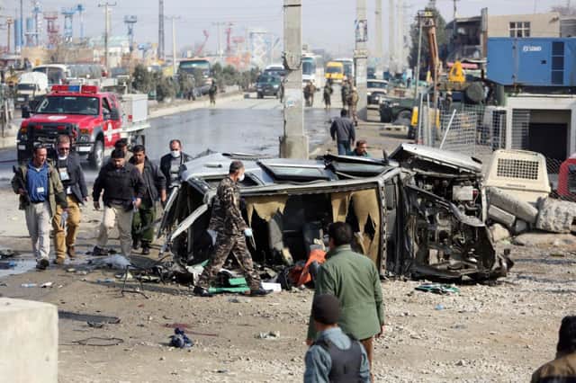 Afghan security forces inspect a British embassy vehicle which was targeted in a suicide attack in Kabul, Afghanistan