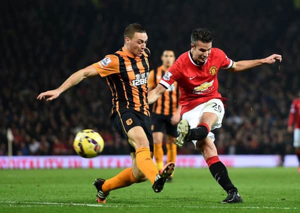 Manchester United's Robin Van Persie scores his side's third goal under pressure from Hull City's James Chester.