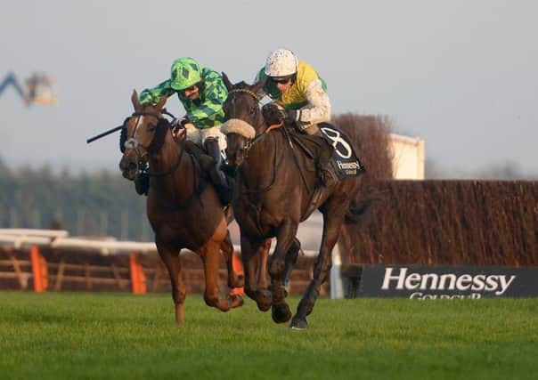 Many Clouds ridden by Leighton Aspell (right) jumps the last to win the Hennessy Gold Cup