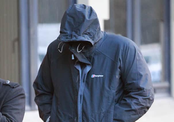 Waheed Iqbal hides his face as he arrives at Bradford Crown Court. Picture: Ross Parry Agency