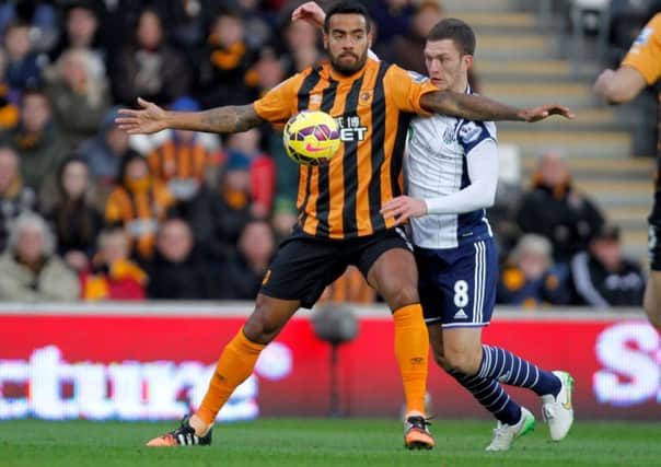 Hull City's Tom Huddlestone (left) holds off West Bromwich's Craig Gardner during the Barclays Premier League match at the KC Stadium, Hull.