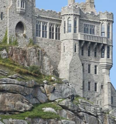 Two of the four-strong gardening team abseiling down the 50 metre (160ft) high walls of St Michael's Mount in Cornwall