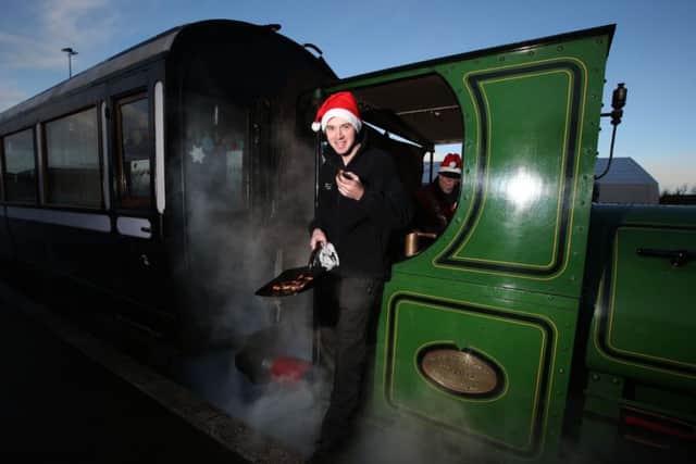 Rail operations manager Noel Hartley enjoys sausages that he cooked on the footplate of the steam locomotive Teddy, as part of a full Christmas dinner