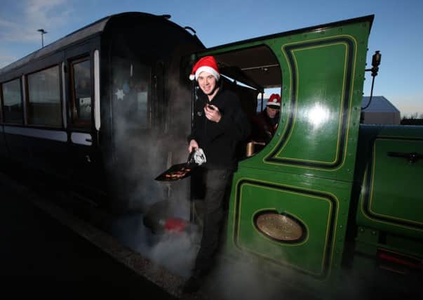 Rail operations manager Noel Hartley enjoys sausages that he cooked on the footplate of the steam locomotive Teddy, as part of a full Christmas dinner