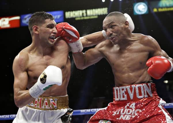 Amir Khan, left, and Devon Alexander trade punches during their welterweight bout on Saturday