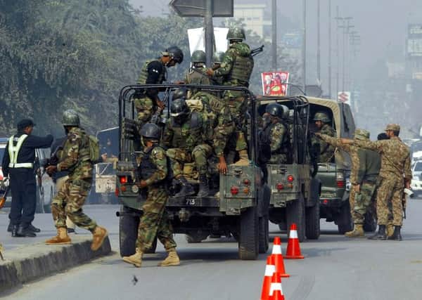 Pakistani army troop arrive to conduct a operation at a school under attacked by Taliban gunmen in Peshawar, Pakistan