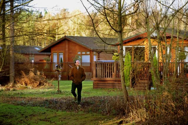 Charlie Forbes Adam walking past the log cabins on the Hollicarrs Holiday Park, part of  the Escrick Park Estate.