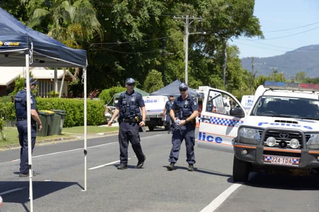Police patrol near a house where eight children have been found dead in a Cairns suburb in far north Queensland, Australia