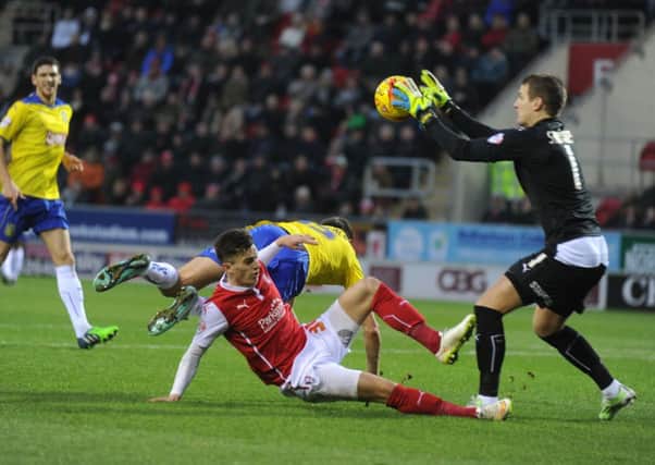Alex Smithies grasps the ball as Tom Lawrence drives in with Murray Wallace closing in.